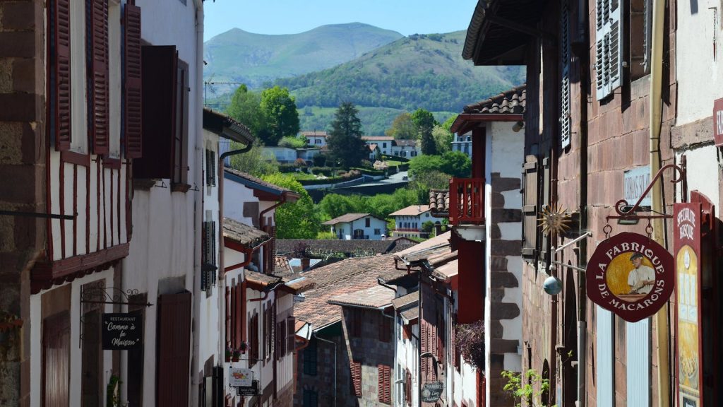 Picturesque alley in Saint-Jean-Pied-de-Port, France, featuring rustic architecture and scenic views.